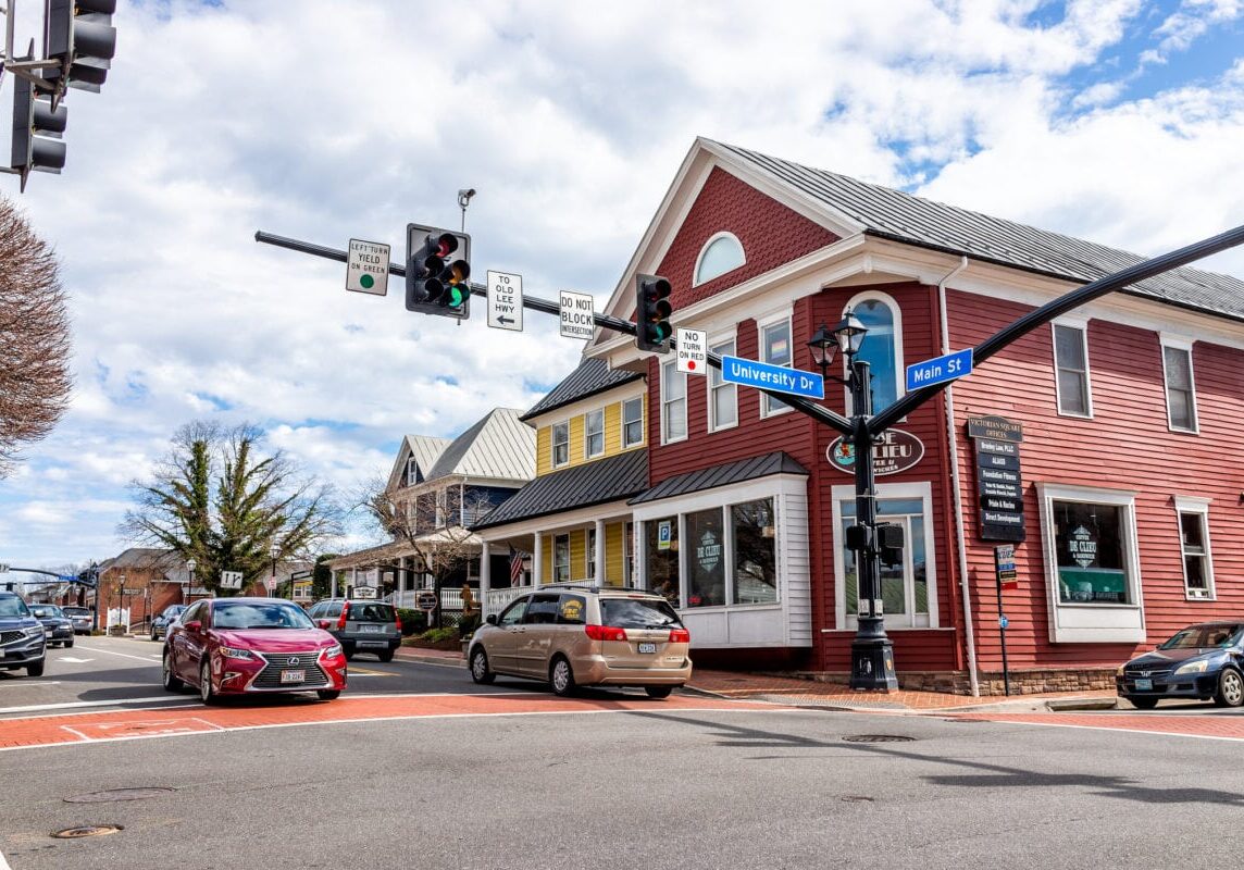 City of Fairfax, USA - March 10, 2020: Downtown old town at University drive, Main street intersection with stores, shops and restaurants in Fairfax county with office buildings in Northern Virginia